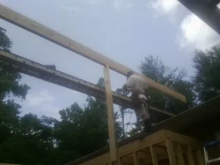 Carpenter setting a ridge beam over a new addition frame — Ice Dam Removal by Roofing Brothers in Los Gatos