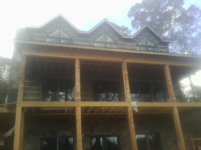 Dormers and porch framing on a large log home under construction — Roof Coating work by our crew in Los Gatos