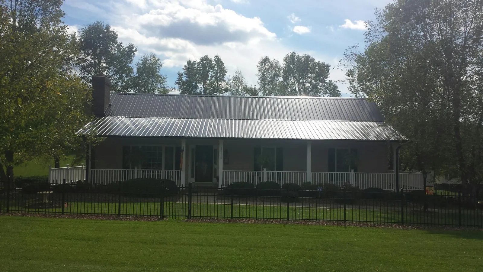 Gray metal roof on a brick ranch with a full width front porch — Gutter Guard Installation work by our crew in Los Gatos